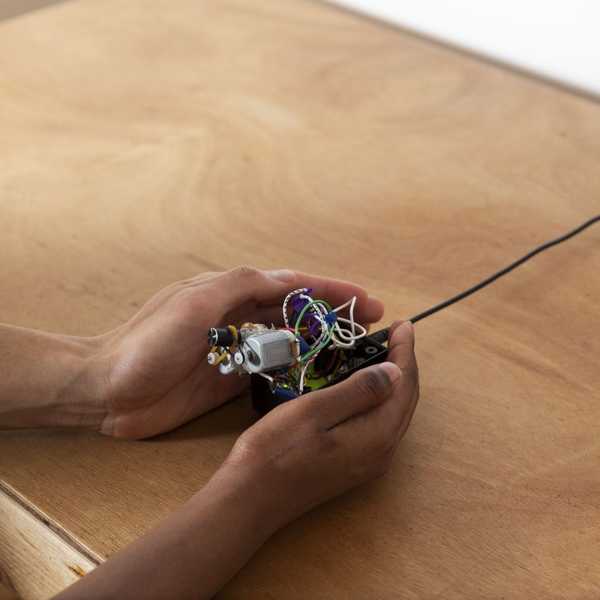 A small device with exposed wires and a single knob.